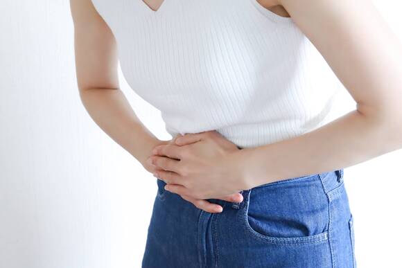 下腹部をおさえる女性