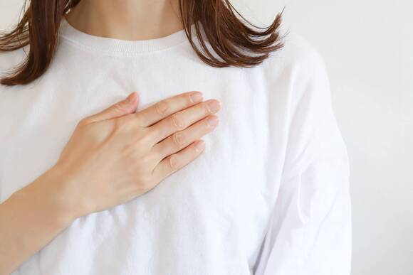 胸に手を当てる女性