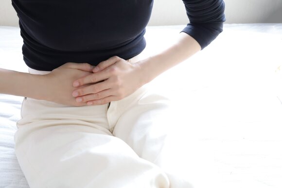 下腹部に手を当てる女性